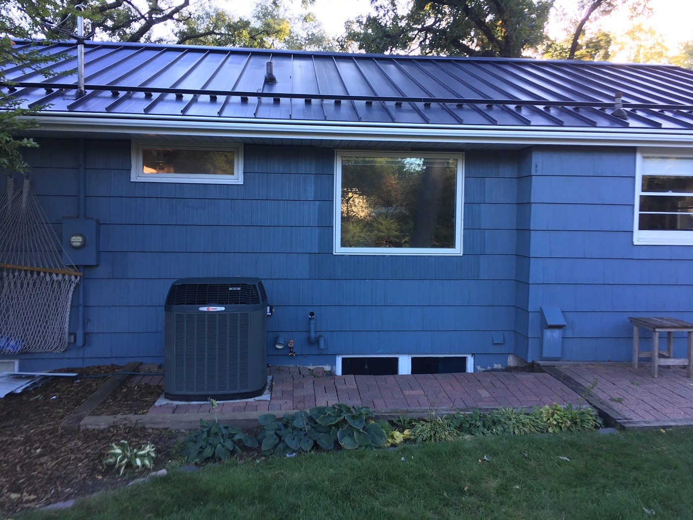 Metal roof on a home with blue siding