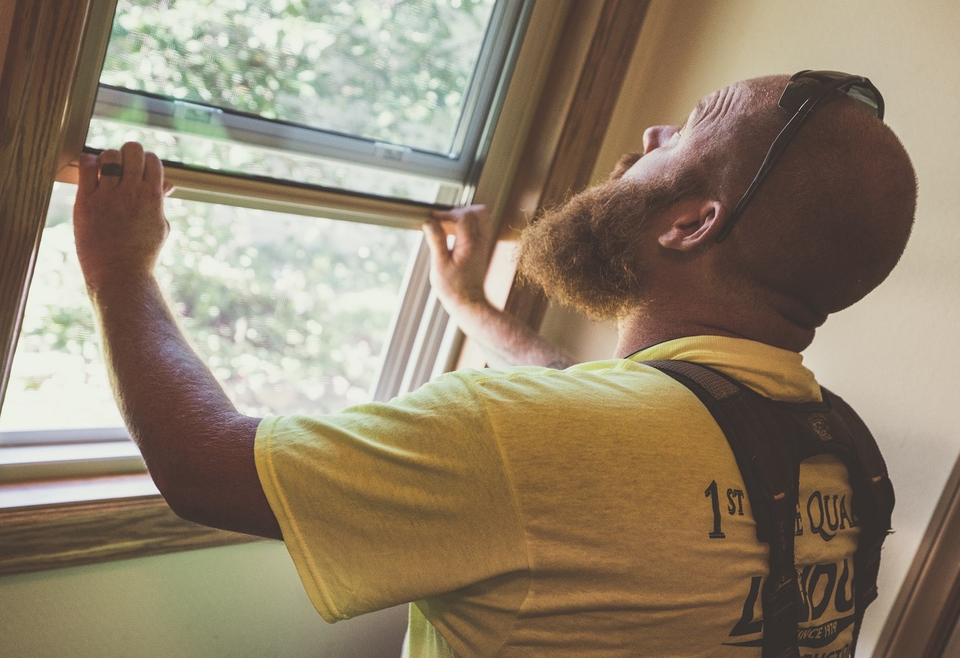 Lindus Construction team member installing a window