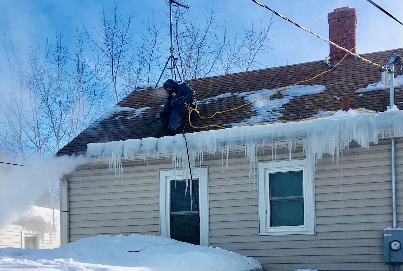 contractor removing ice dams from roof