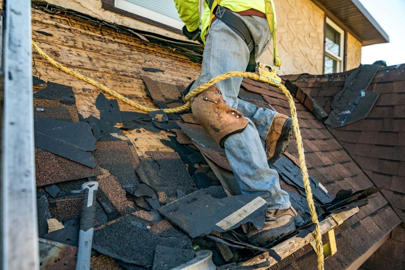  roofer removing old roof shingles