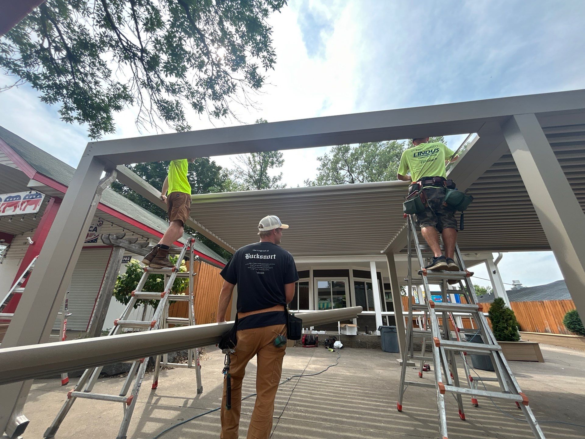 Lindus Construction craftsmen installing a StruXure Pergola X with Pivot 6 louvers at the WCCO Radio booth at the Minnesota State Fair.